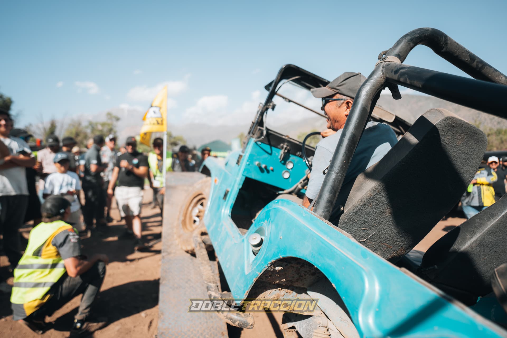 Jeep celeste clásico esperando su turno en la rampa de articulación