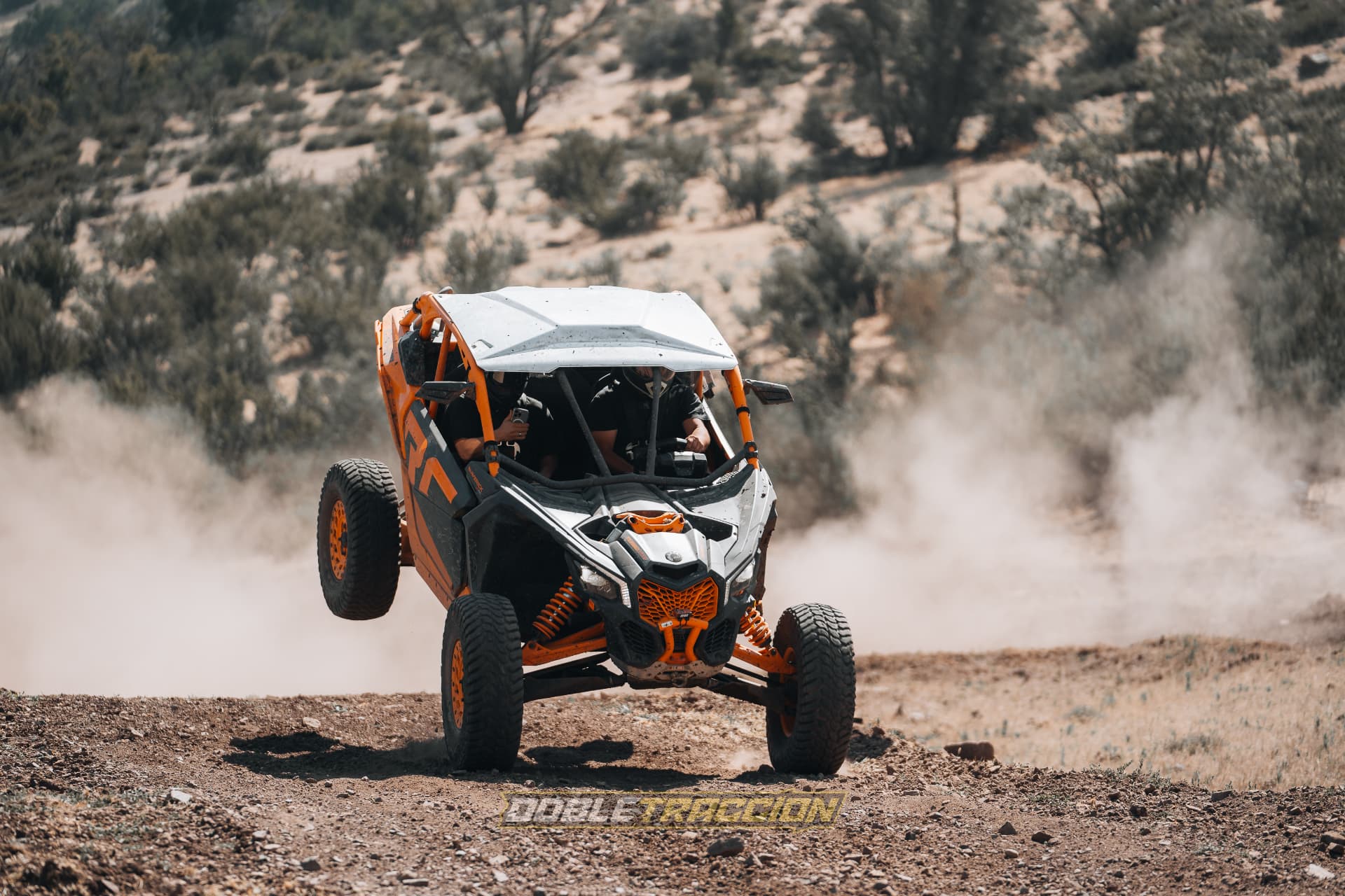 UTV Can-Am naranjo saliendo de la nube de polvo