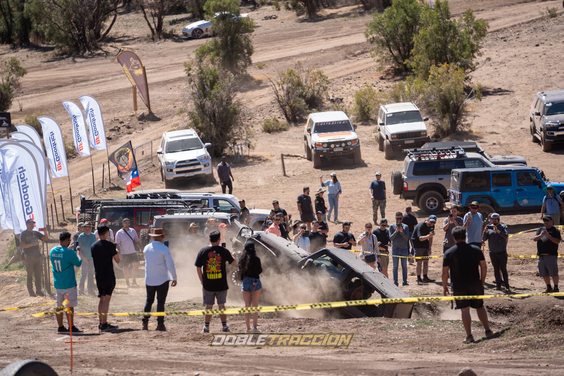 Vehículo 4x4 en el hoyo rodeado de público y banderas BFGoodrich